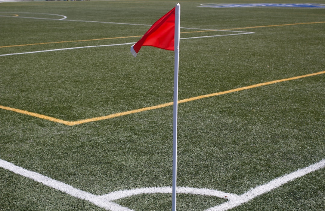 white and red flag on green field during daytime football red card referee match foul