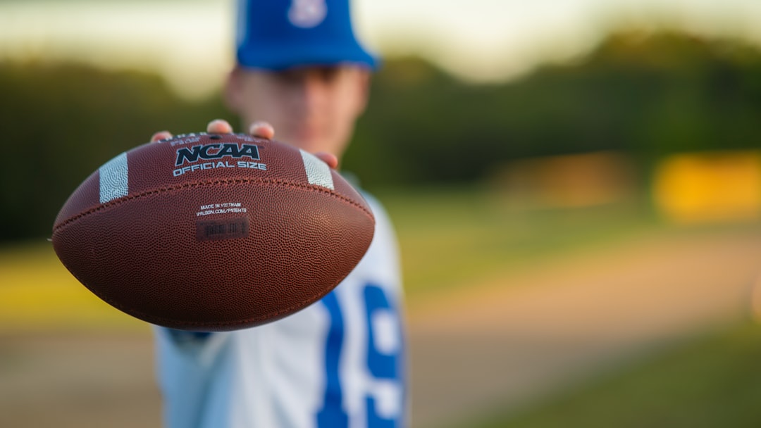 a close up of a person holding a football college sports, ai recruiting, data analysis