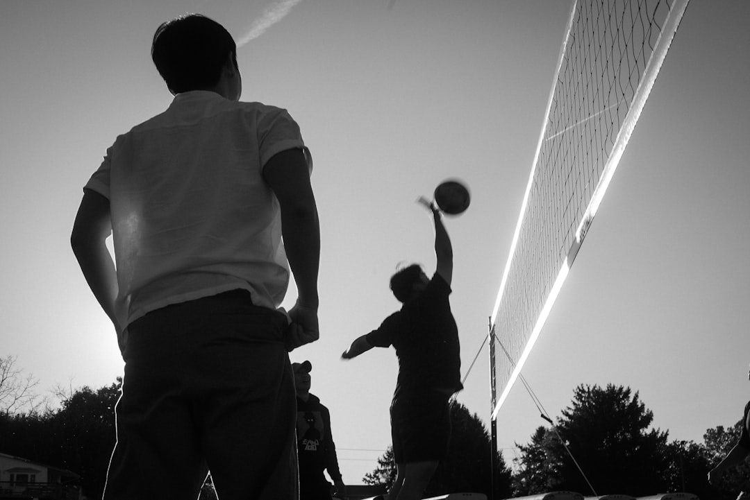 A couple of men standing on top of a tennis court high school sports AI data