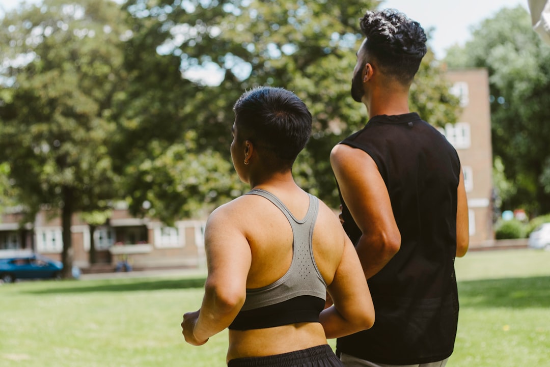 a couple of people that are standing in the grass inclusive fitness diverse gym people