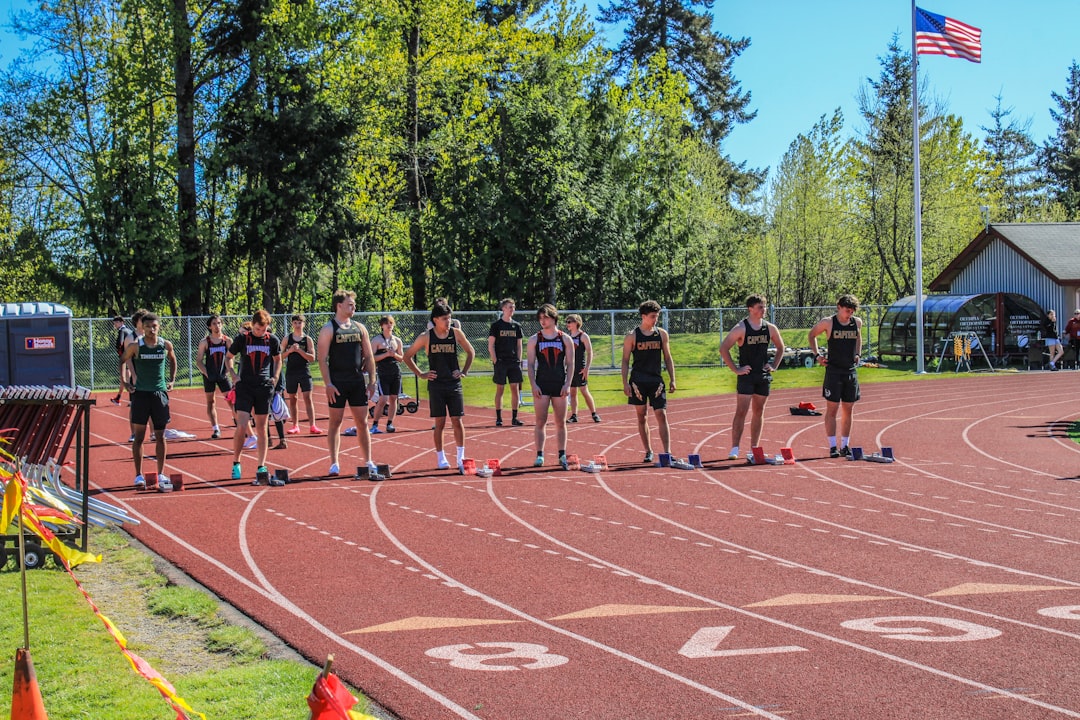 a group of people standing on top of a track training camp, athlete performance, wearables