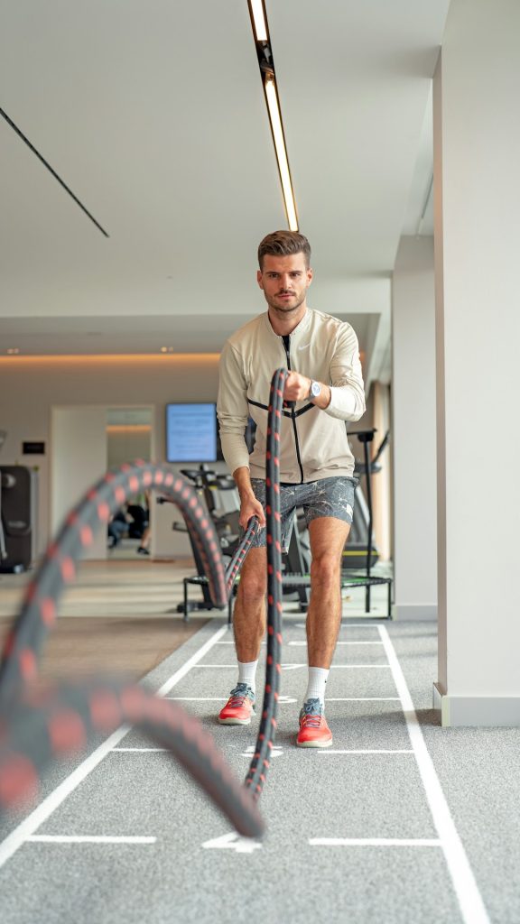 a man is holding a rope in a gym gym workout weightlifting muscle