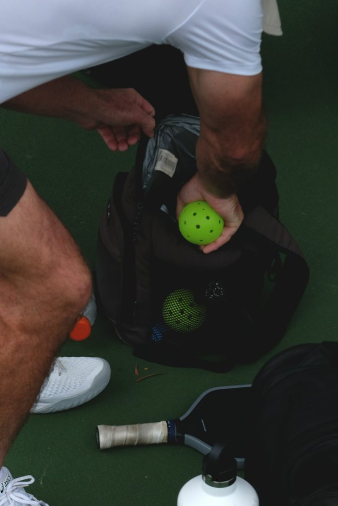 A person is taking pickleballs from a bag. wearable sensors athlete tracking