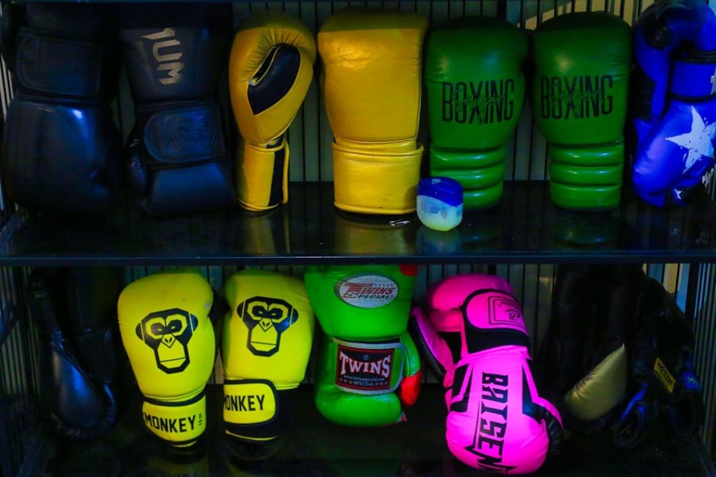 a shelf filled with different colored boxing gloves boxing gloves, betting slip, excitement