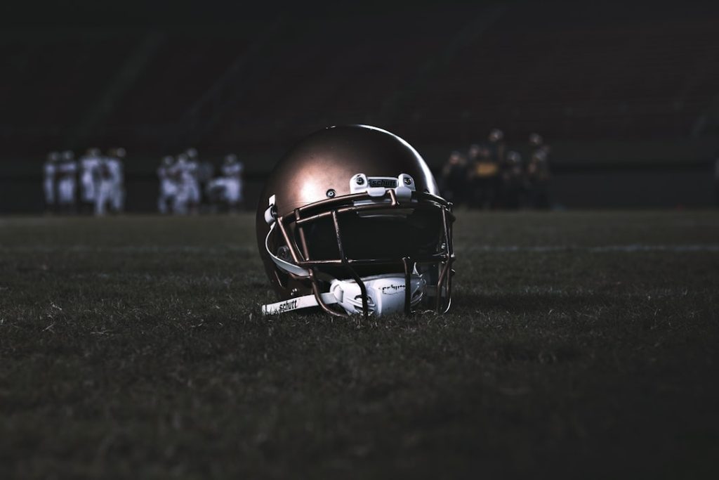 football helmet on green grass field during night time college sports, ai recruiting, data analysis