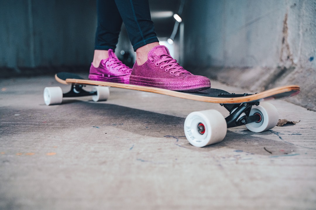person in purple nike sneakers riding white and black skateboard skateboard trick, vert skating, motion, extreme sports