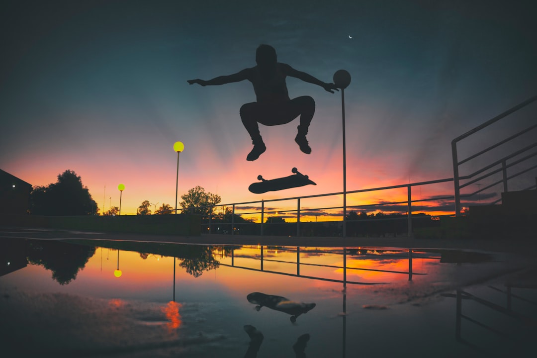 silhouette of skateboard player doing exhibition on park skateboard trick, vert skating, motion, extreme sports