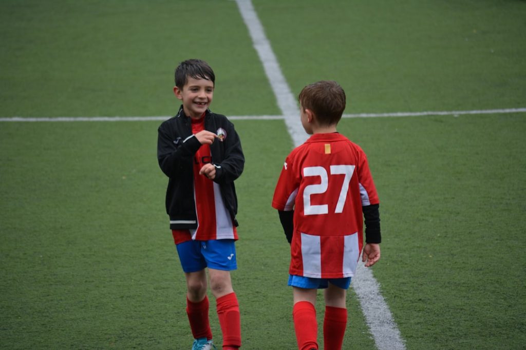 two boy standing on soccer field barcelona benfica players match