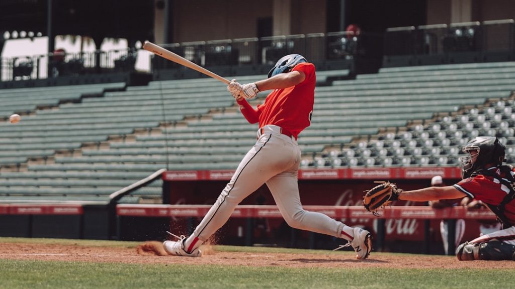 woman in red jersey shirt and white shorts holding baseball bat Kyler Murray, Arizona Cardinals, rookie season