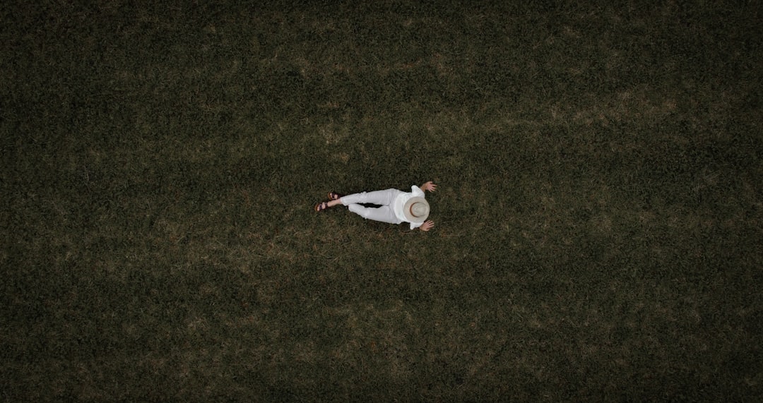 woman in white long sleeve shirt lying on green grass field during daytime Josh Rosen, Arizona Cardinals, dejected