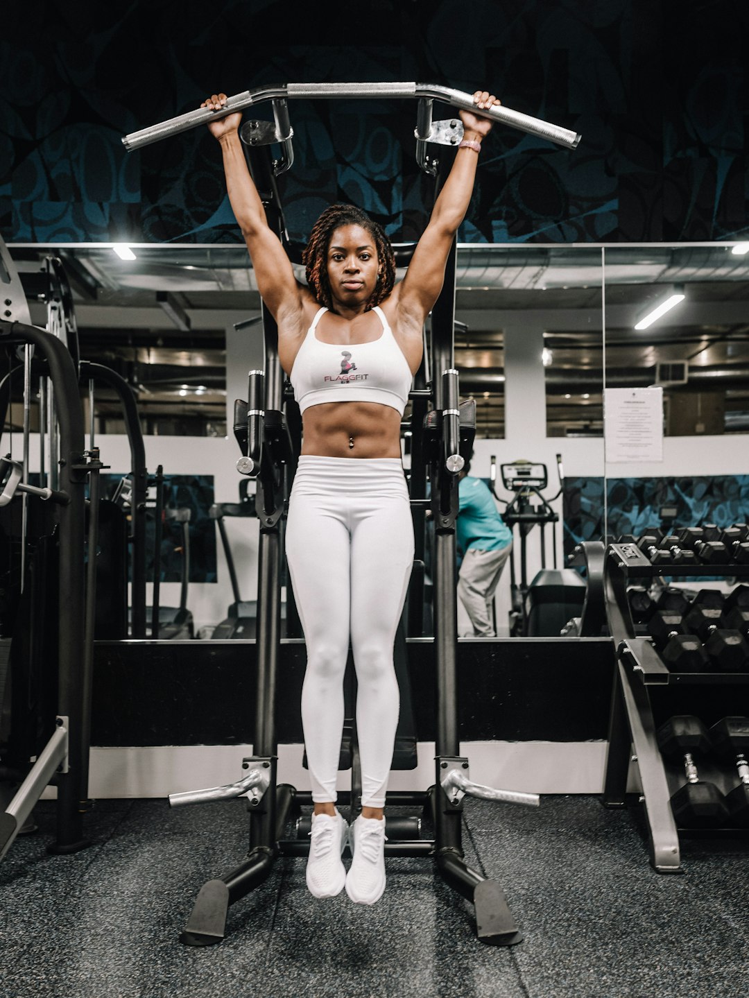 woman in white tank top and white pants doing exercise gym workout weightlifting muscle