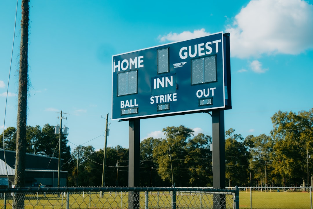 A baseball field with a large sign on it football players scoreboard high school