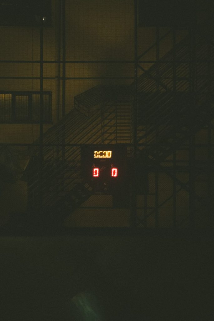 a clock that is on a building in the dark football scoreboard stats shot goal pass possession