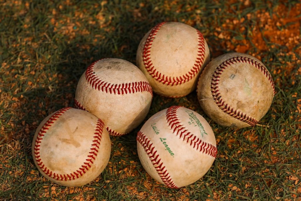 a group of baseballs on the ground baseball batter leadoff stats field