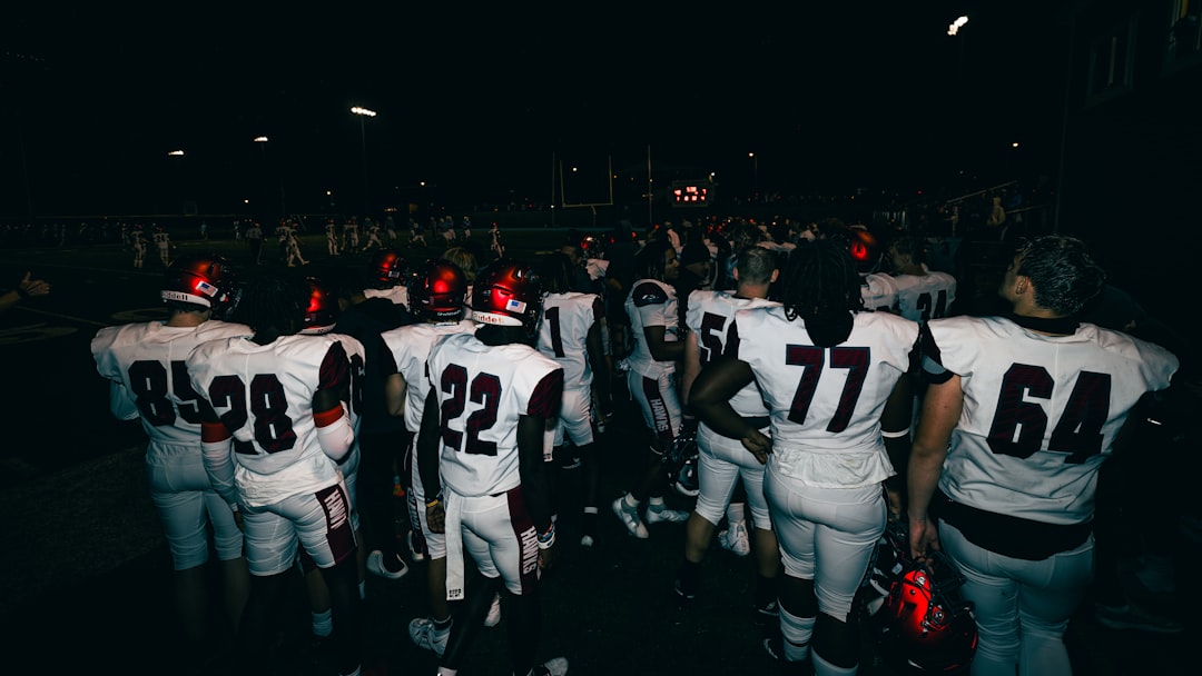 a group of football players high school football fans bleachers night game