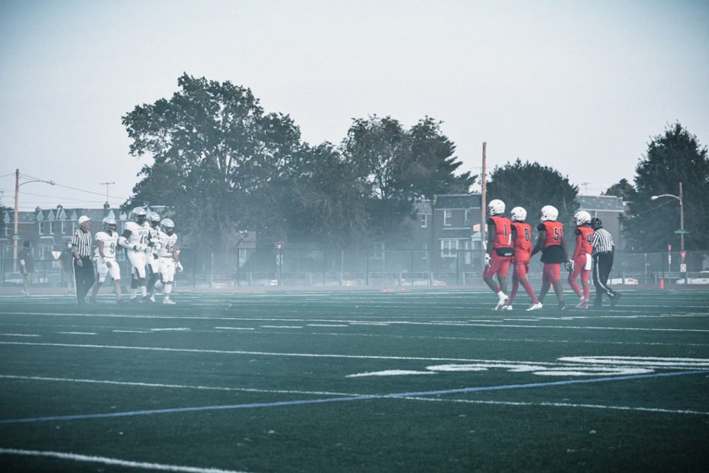 a group of people on a field playing football wicksburg football training, high school athletes lifting, early morning practice