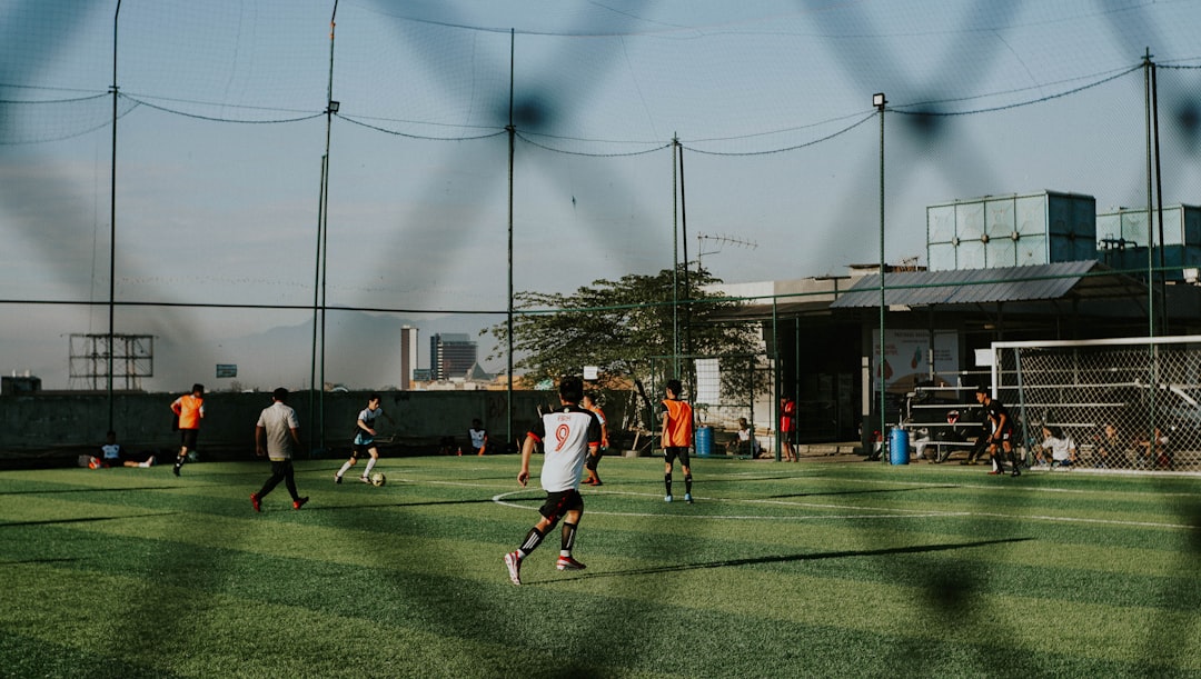 a group of people playing a game of soccer teambuilding activities, high school football huddle, players bonding