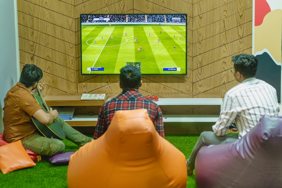 a group of people sitting in front of a flat screen tv football community, fans chatting, online sports discussion