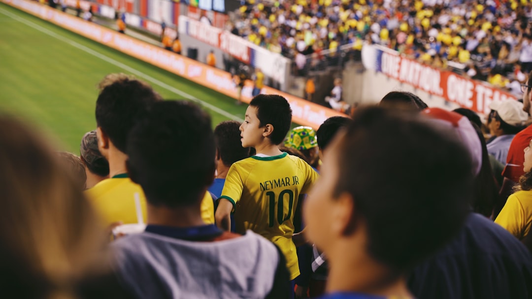 a group of people standing on top of a soccer field soccer fans, intense match, stadium atmosphere, rival team flags