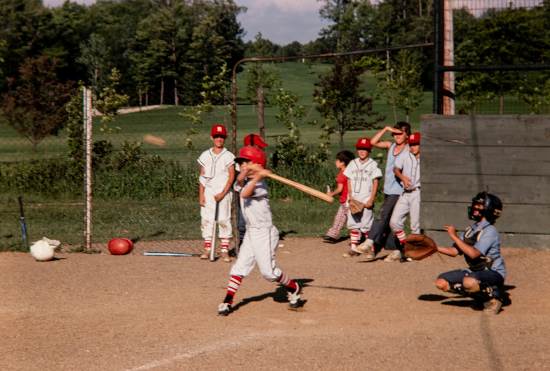 a group of young boys playing a game of baseball youth baseball equipment gear dugout