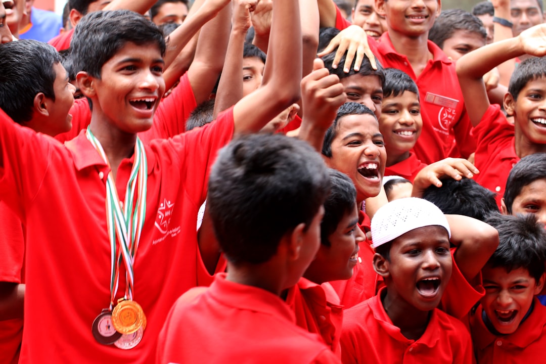 a group of young boys standing next to each other football championship, high school trophy, players celebrating