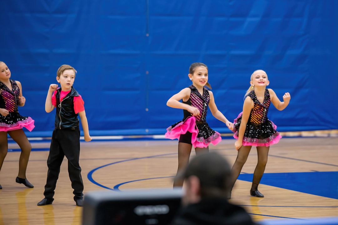 a group of young girls standing on top of a basketball court competitive ballroom dance, dance competition, athletic dancers
