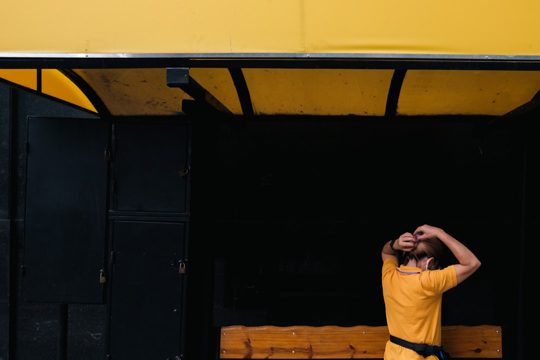 a man in a yellow shirt standing in front of a bench rookie player coach bench sideline