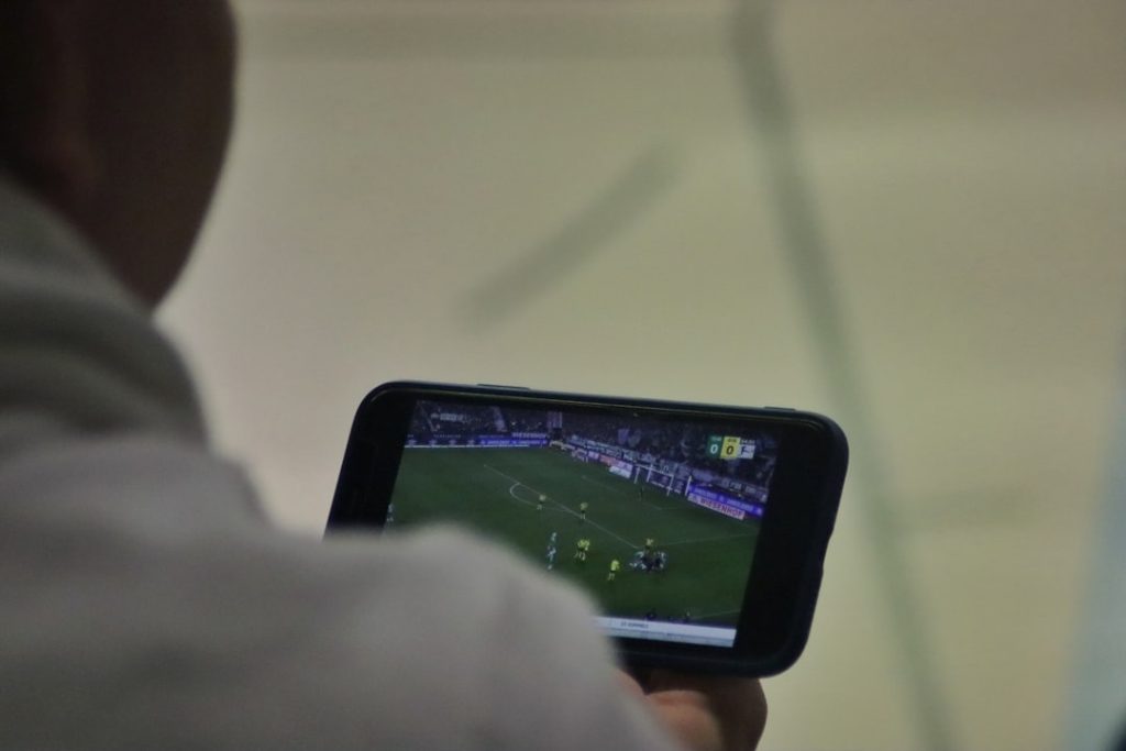 a man is playing a soccer game on his phone football player smart gear data analytics tablet