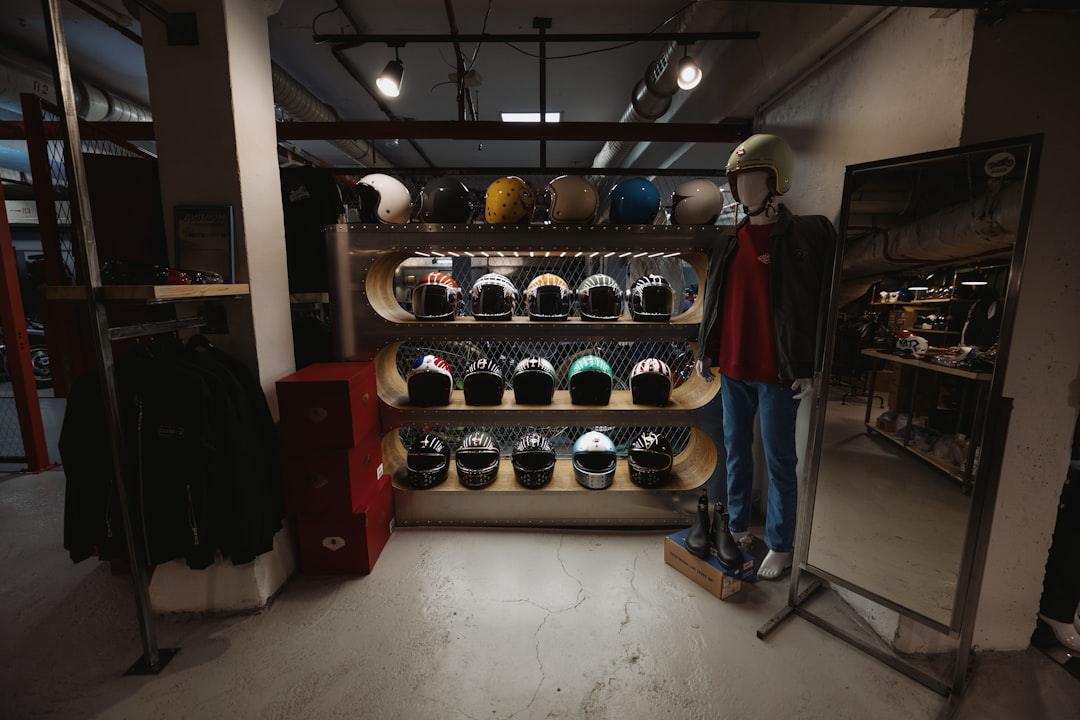 a man standing in front of a rack of hats football gear fitting, player trying vest, locker room