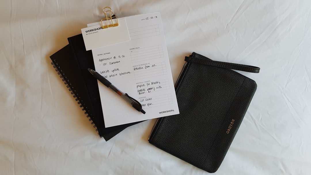 a notepad, pen, and notebook on a bed sports diary, paper notes, betting slips