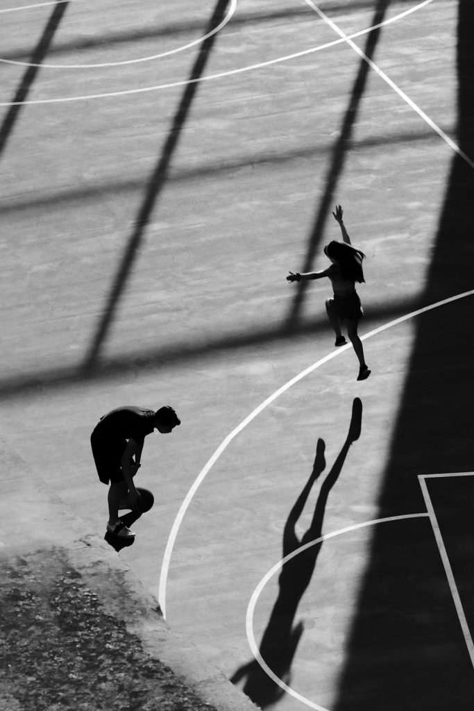 A person jumping up into the air on a basketball court sports analytics, teamwork, cybersecurity measures