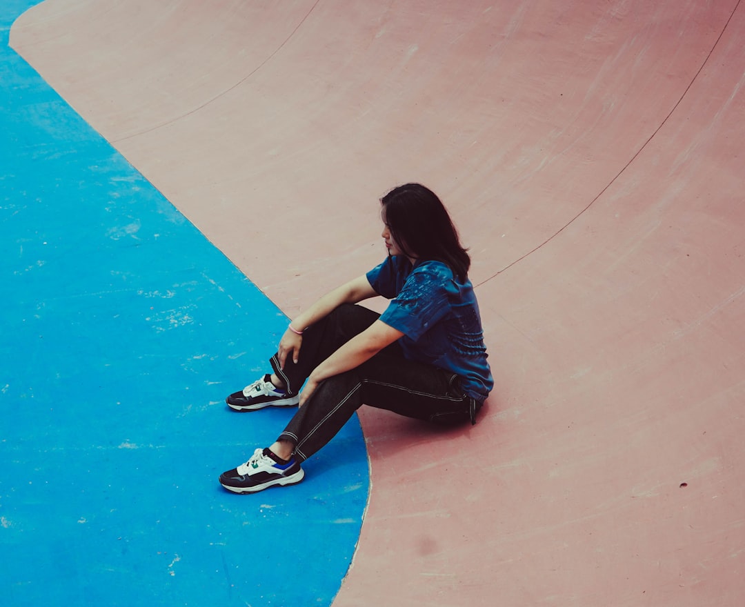 a person sitting on a skateboard in a skate park sad person, losing streak, motivation
