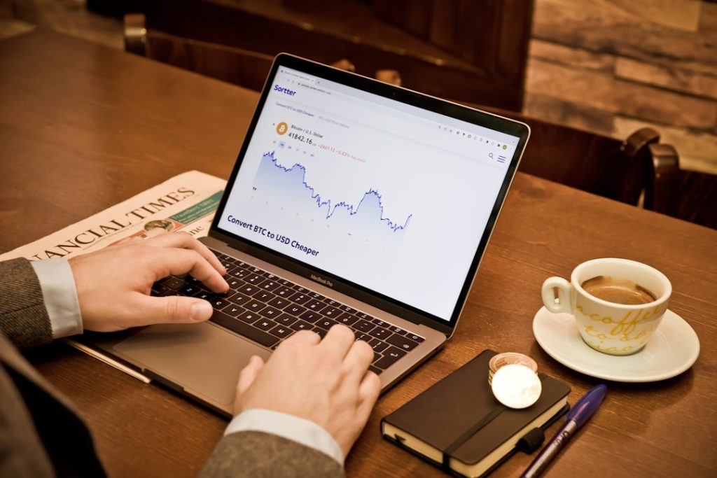 a person using a laptop on a wooden table bettor with laptop, custom rankings, data analysis
