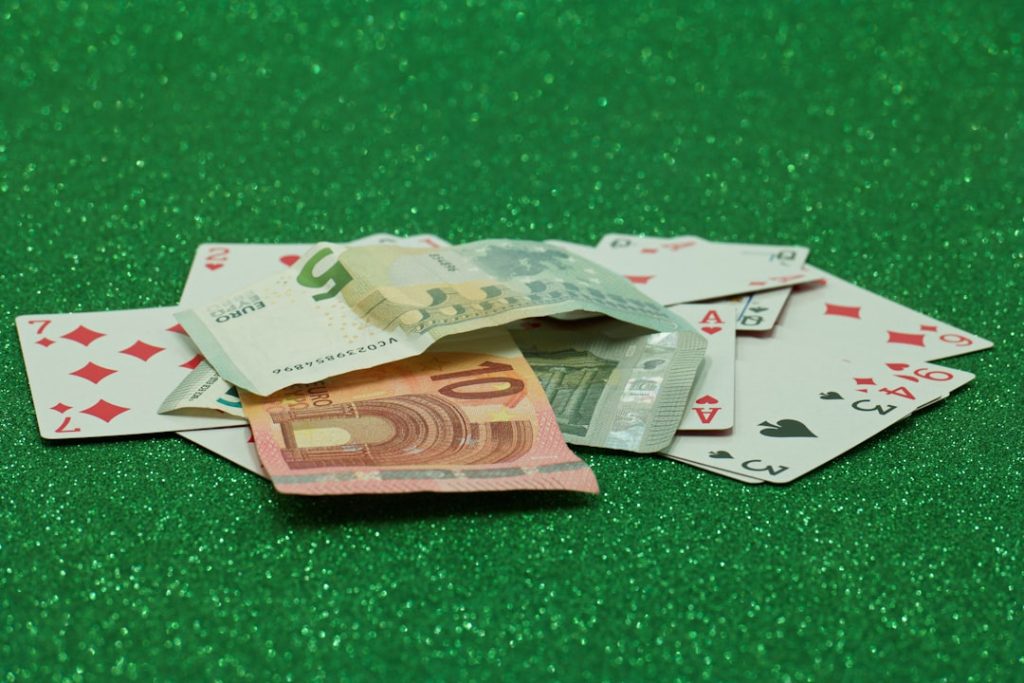 a pile of playing cards sitting on top of a green table sports betting app, walking away, bankroll management