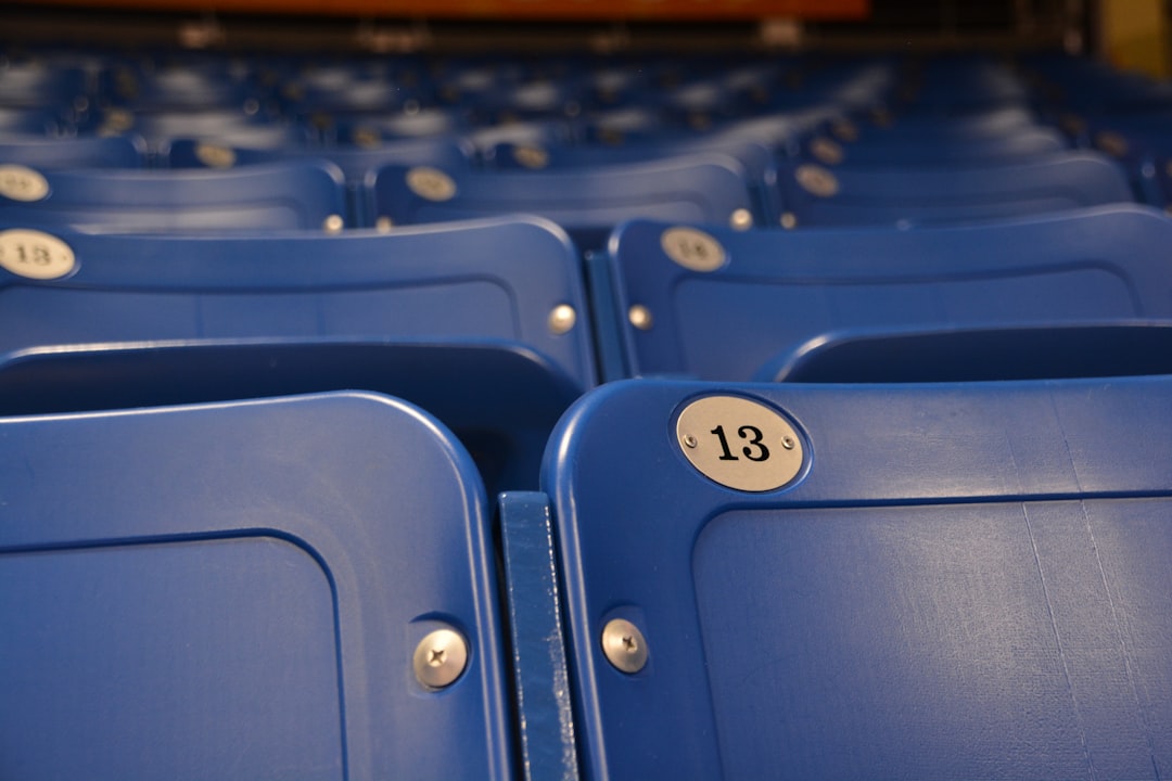 a row of blue seats with the number thirteen on them wildcatters baseball stadium fans