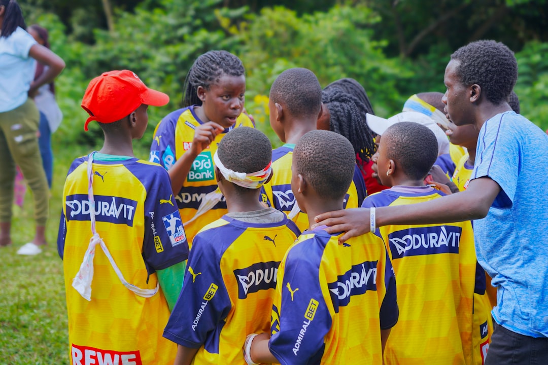 A soccer team huddles together for a pep talk. youth football, division jerseys, team huddle