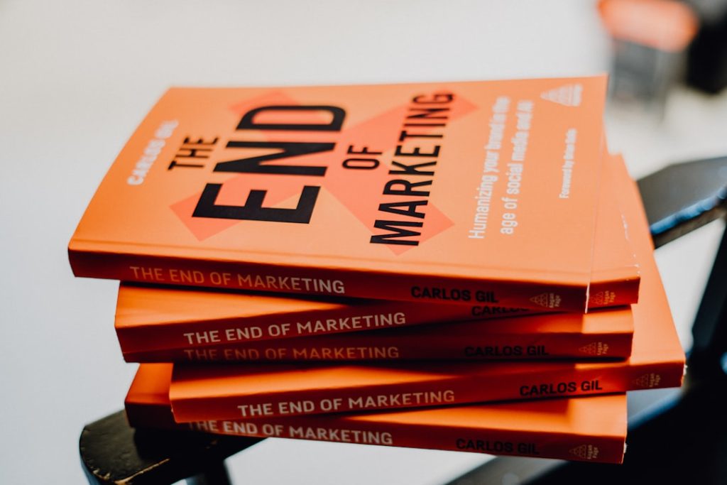 a stack of orange books sitting on top of a chair sales meeting metrics marketing