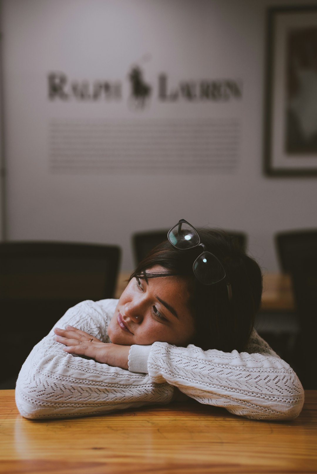 a woman sitting at a table with her head resting on her hands student sleeping, rest day, recovery