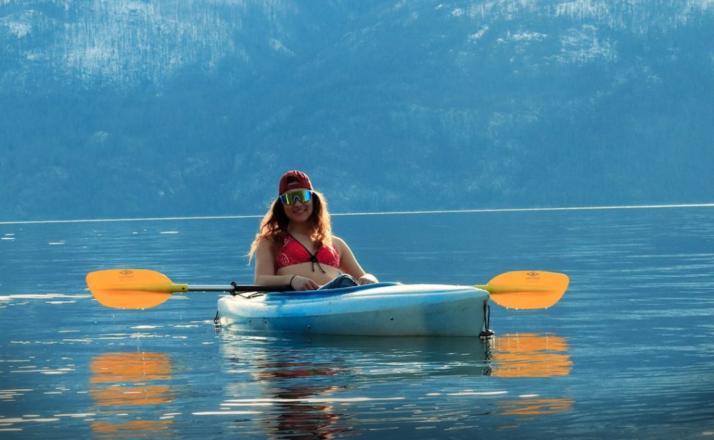 a woman sitting in a kayak on a lake lake tahoe,kayaking,beginners,paddleboarding