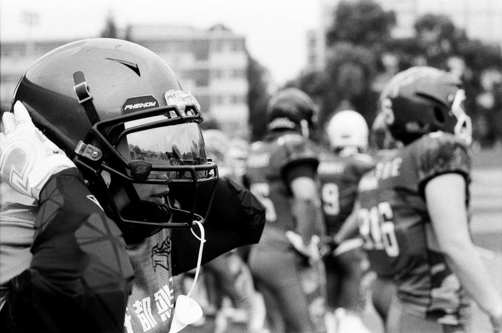 American football players prepare on the sidelines. football helmet smart technology coaching sideline