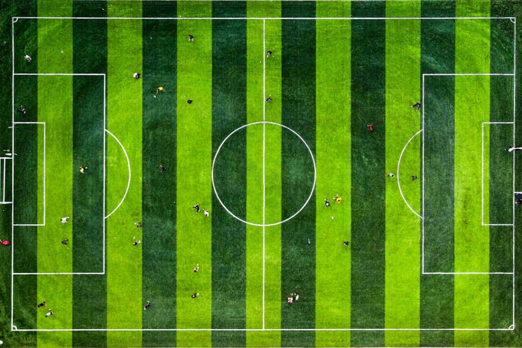 an aerial view of a soccer field football scoreboard stats shot goal pass possession