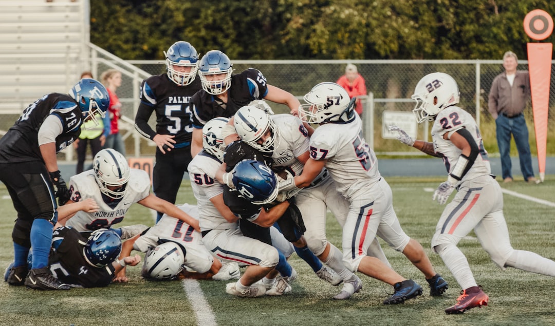 Football players in a pile up during a game. youth football, division jerseys, team huddle