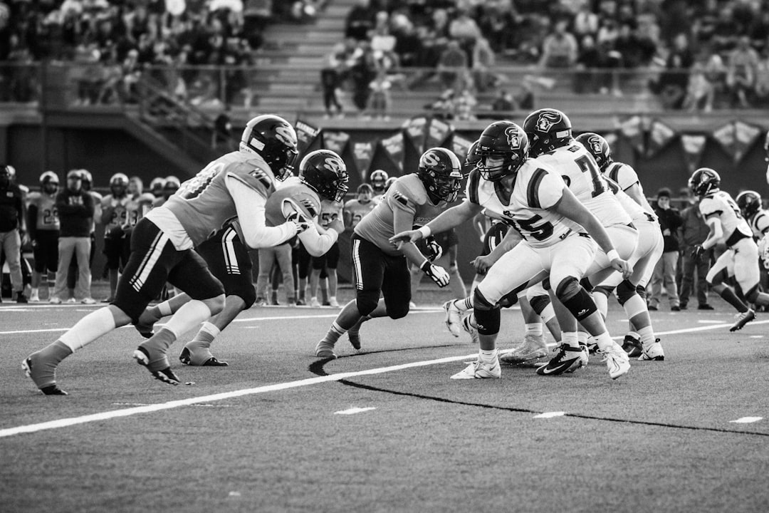 Football players in action during a game. nfl defense sack, quarterback pressure moment, stadium lights football