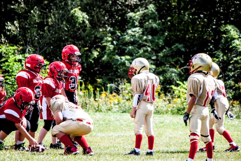 football players on green grass field during daytime tallmadge players, game action, quarterback throwing