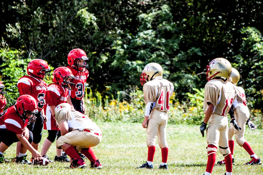 football players on green grass field during daytime tallmadge players, game action, quarterback throwing