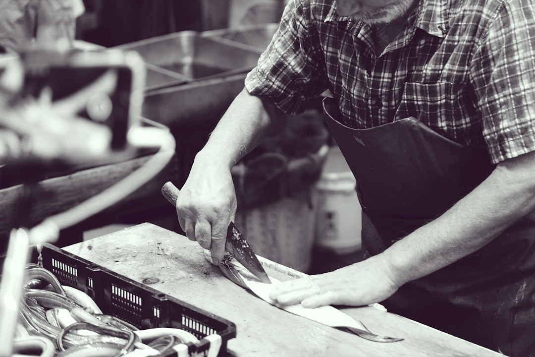 grayscale photography of man using knife handmade business, product photography, e commerce tips