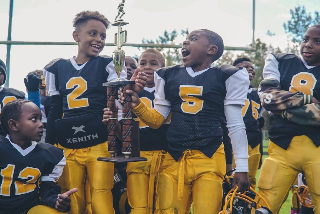 group of children football team football championship, high school trophy, players celebrating