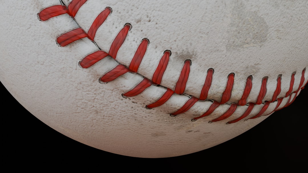 Here's a possible caption: baseball closeup with red stitching. close up baseball pitcher release point, high arm angle, fastball motion