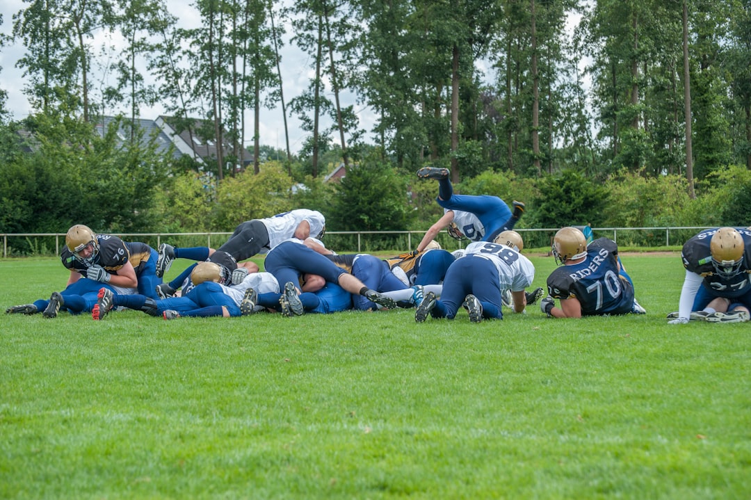 men playing football teambuilding activities, high school football huddle, players bonding