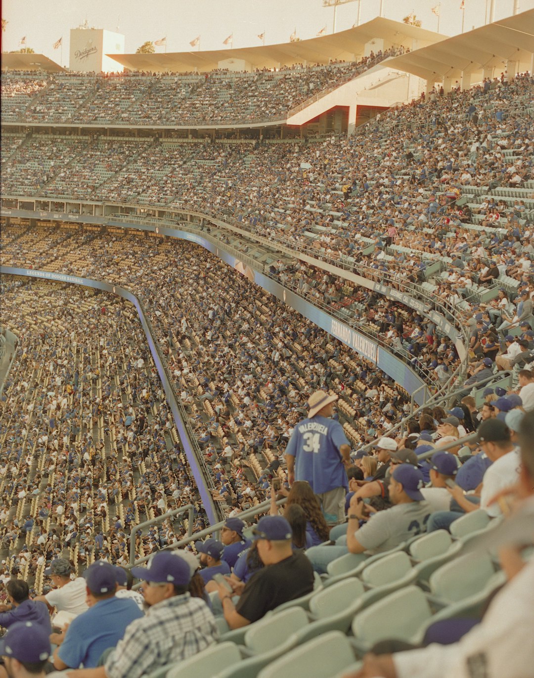 people sitting on blue chairs during daytime nfl preseason football stadium crowd